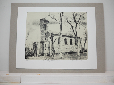 Das Foto zeigt eine Monotypie, ein Foto, das von der Künstlerin Heike Pander von Hand auf einer Gel-Platte gedruckt wurde. Darauf zu sehen ist die Kirche in Altglietzen im Winter. Die Grundlage für die Monotypie bildet ein Foto, das die Künstlerin vor Ort aufgenommen hat. Das Motiv ist in schwarz gedruckt, der Hintergrund ist beige.
